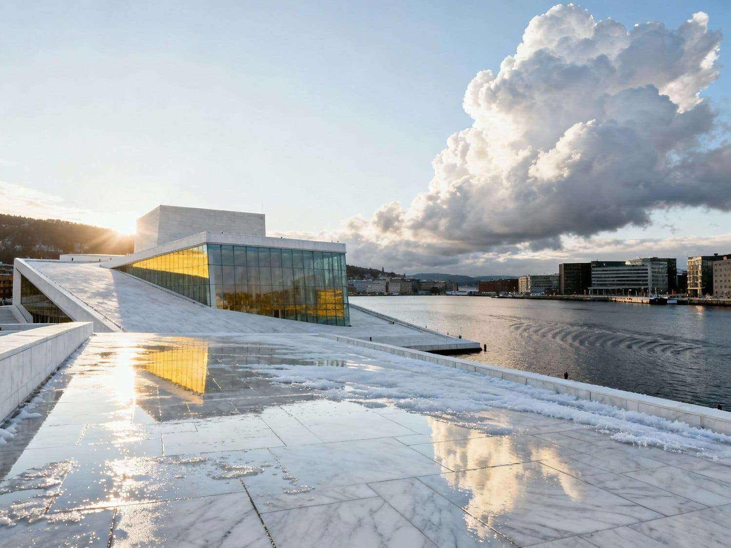 The pavilion at sunset, its single sloping roof turned toward the water under dramatic cloud
