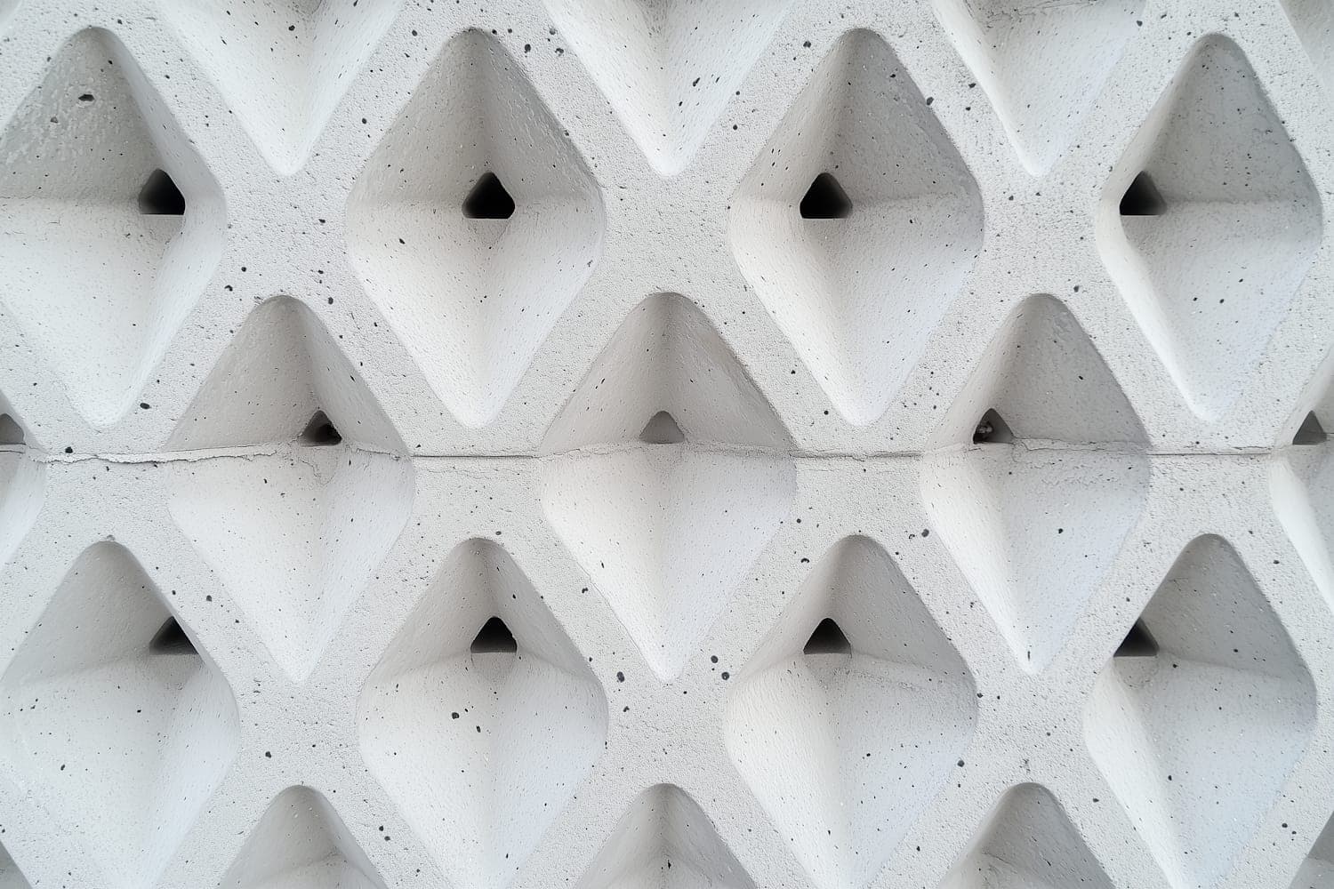Close detail of a precast concrete lintel cast with a shallow diamond relief